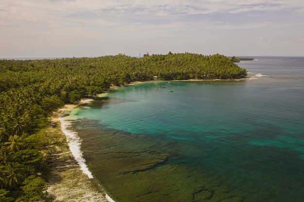 인도네시아의 하얀 모래와 청록색 맑은 물이있는 해안선의 매혹적인 전망
