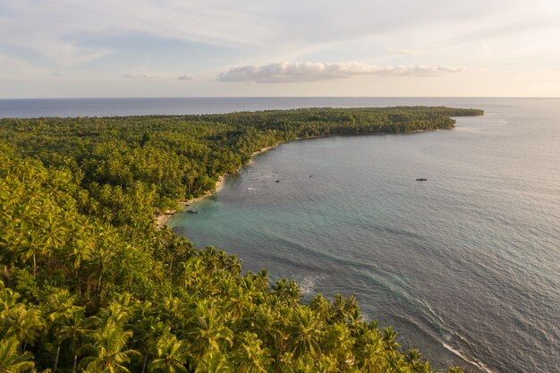 インドネシアの白い砂浜とターコイズブルーの澄んだ水で魅惑的な海岸線の景色