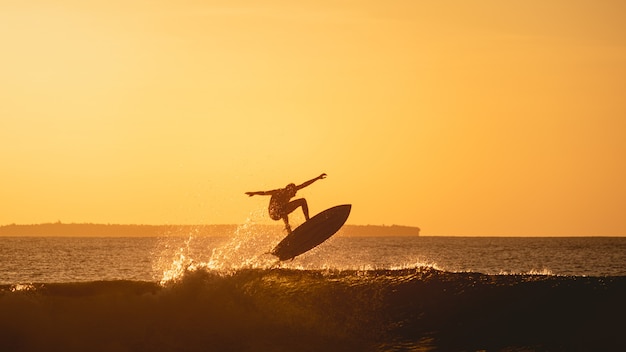 Mesmerizing view of the silhouette of a surfer in the ocean during sunset in Indonesia