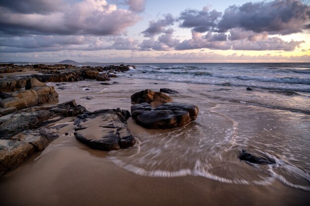 Mesmerizing view of the sunset over rocky seashore in Kap Geinitzort in Rostock, Germany