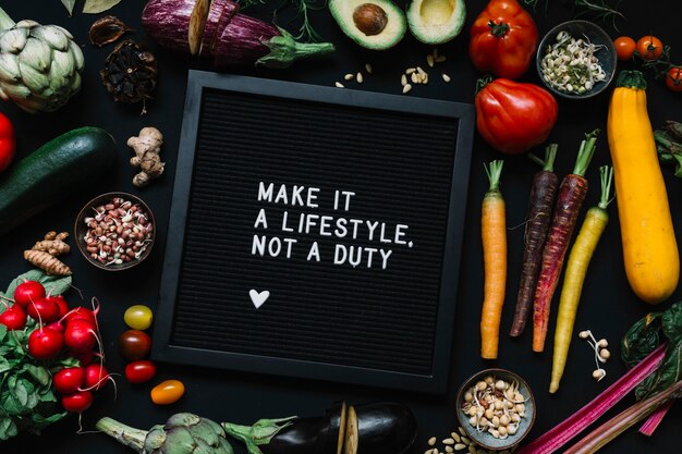 Message on black frame surrounded with vegetables against black backdrop