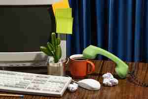 Free photo messy office desk with old computer still life