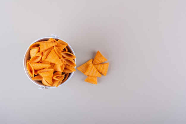 Metal bucket of triangle chips on white background. High quality photo