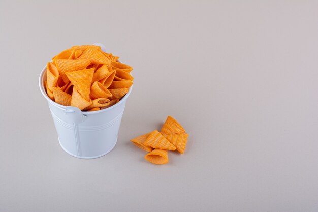 Free photo metal bucket of triangle chips on white background. high quality photo