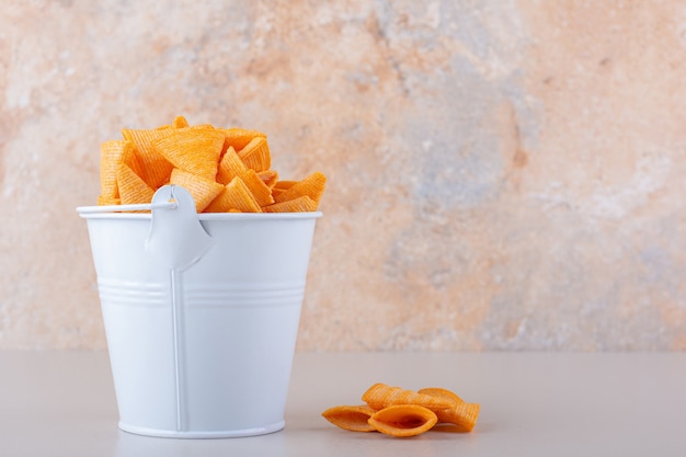 Free photo metal bucket of triangle chips on white background. high quality photo