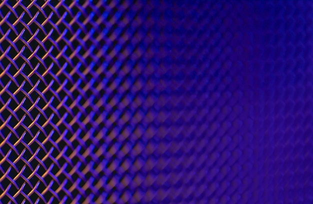 Free photo metal grill closeup texture of a music speaker in colored lighting