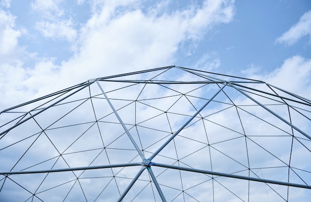 Metal structure against the blue sky with white clouds.