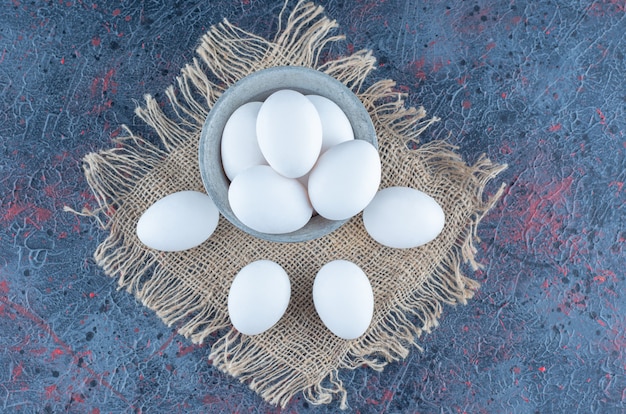 A metallic bucket with raw fresh chicken eggs 