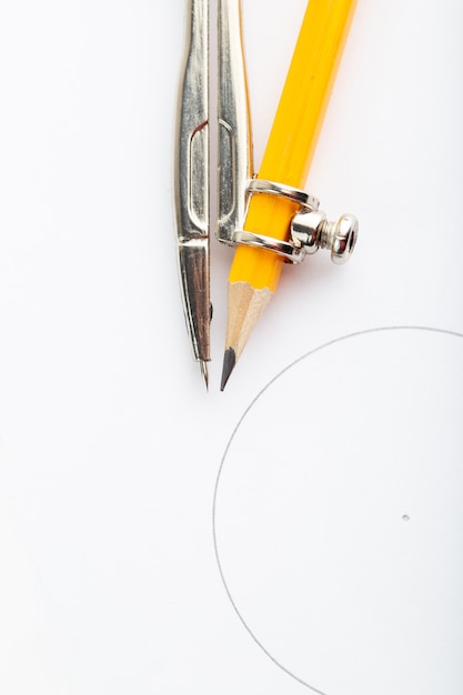 Metallic compass isolated with pencil a top view on white