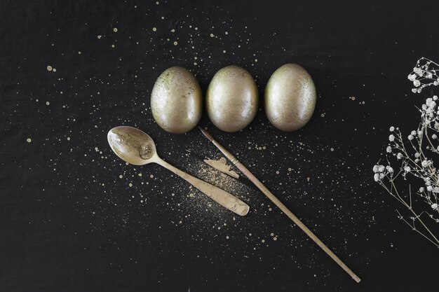 Metallic eggs near brush and spoon