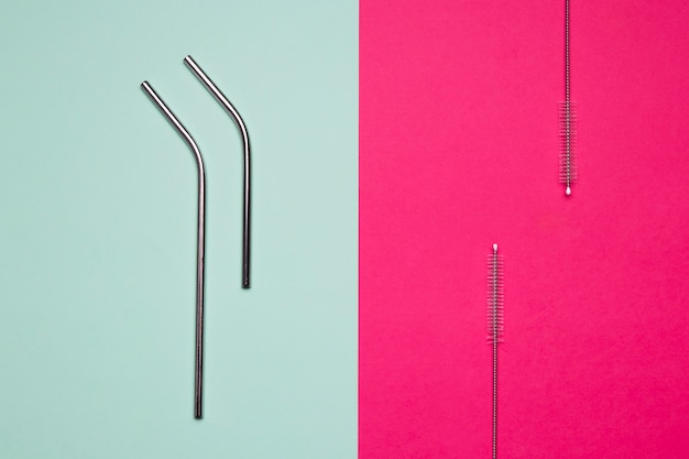 Free photo metallic straws on bicolored background