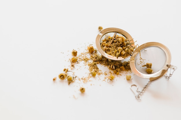 Metallic tea strainer on white table