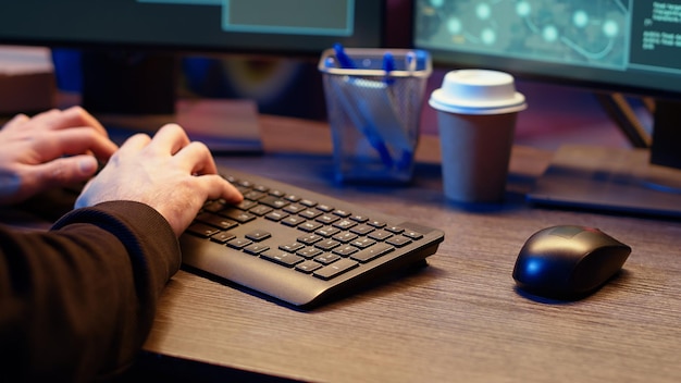 meticulous hacker typing on computer keyboard close up