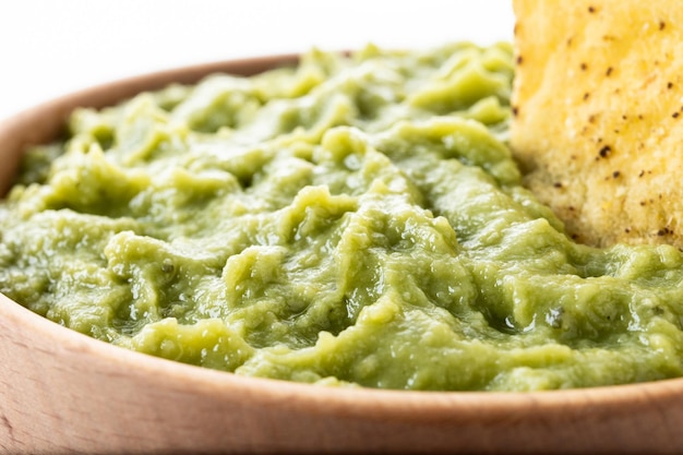 Mexican guacamole with nacho chip isolated on white background