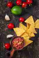 Foto gratuita le patatine fritte e la salsa messicane del nacho si tuffano in ciotola su di legno