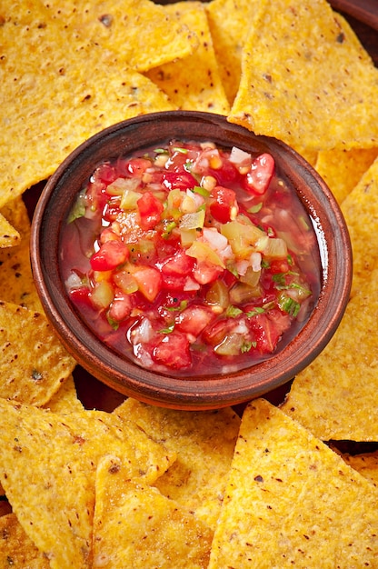 Free photo mexican nacho chips and salsa dip in  bowl on wooden