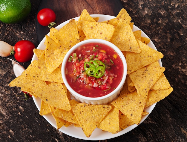 Mexican nacho chips and salsa dip in  bowl 