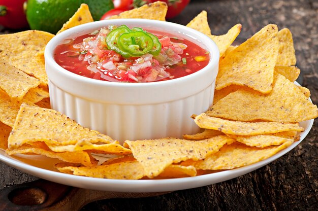 Mexican nacho chips and salsa dip in  bowl 