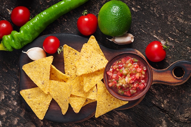 Mexican nacho chips and salsa dip in  bowl 