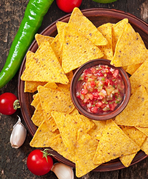 Mexican nacho chips and salsa dip in  bowl 