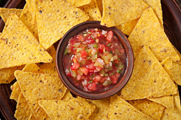 Mexican nacho chips and salsa dip in  bowl