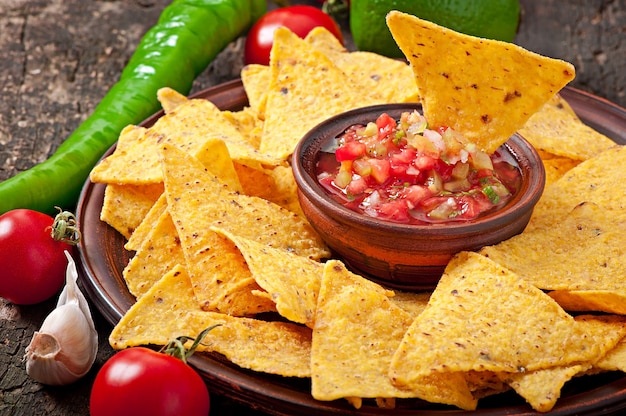 Mexican nacho chips and salsa dip in  bowl