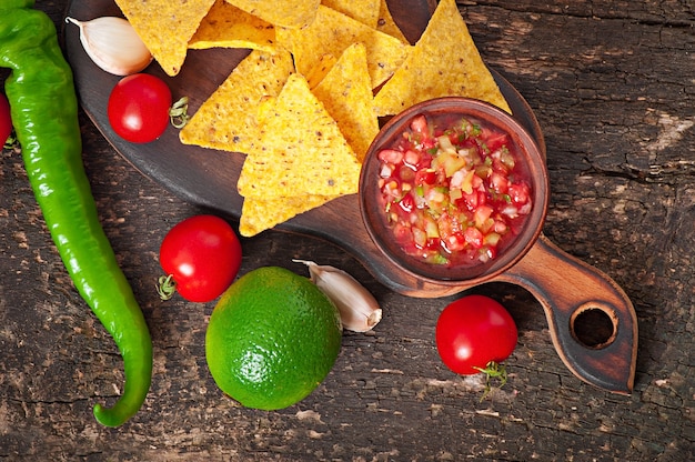 Mexican nacho chips and salsa dip in  bowl