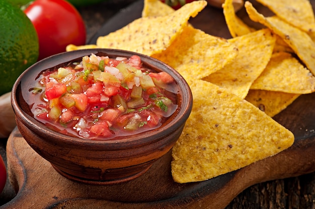 Mexican nacho chips and salsa dip in  bowl