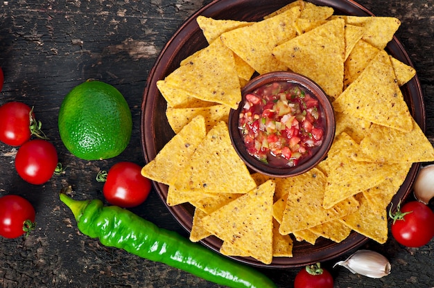 Mexican nacho chips and salsa dip in  bowl