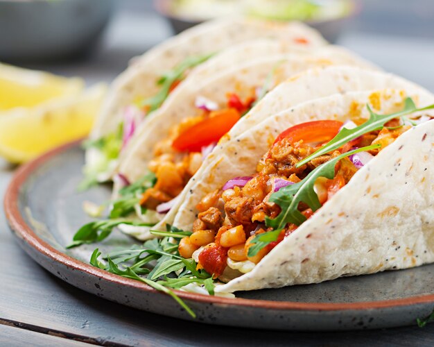 Mexican tacos with beef, beans in tomato sauce and salsa