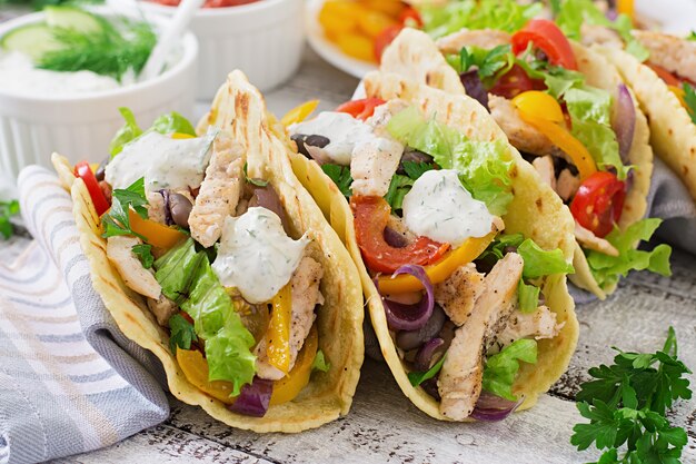 Mexican tacos with chicken, bell peppers, black beans and fresh vegetables