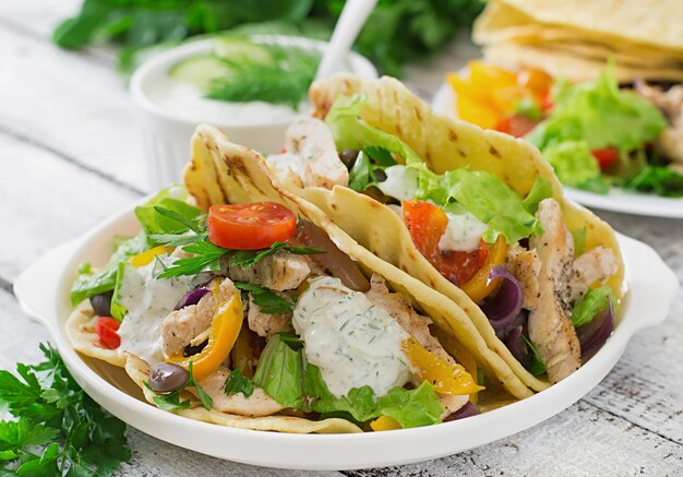 Mexican tacos with chicken, bell peppers, black beans and fresh vegetables