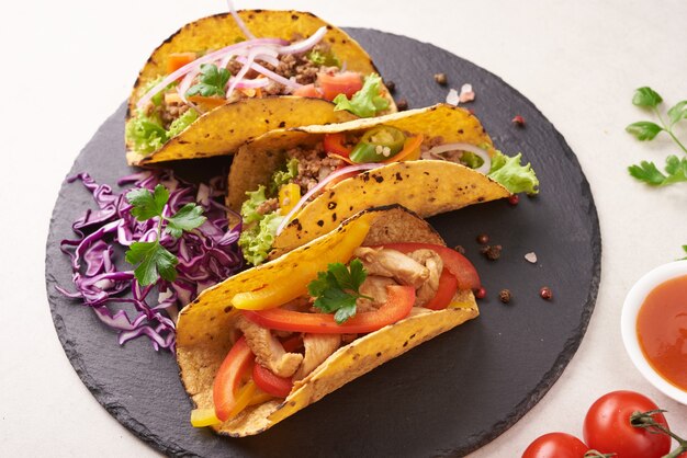 Mexican tacos with meat, pork carnitas street tacos in yellow corn tortilla with onion, cilantro and cabbage. red cabbage. Top view. flat lay.