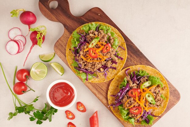 Mexican tacos with meat, pork carnitas street tacos in yellow corn tortilla with onion, cilantro and cabbage. red cabbage. Top view. flat lay.