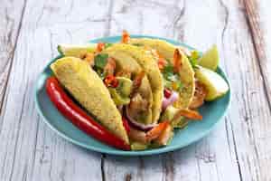 Foto gratuita tacos messicani con gamberettiguacamole e verdure su tavola di legno