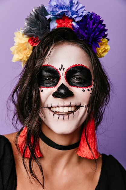 Мексиканская женщина в маске в прекрасном настроении с белоснежной улыбкой позирует для портрета крупным планом.