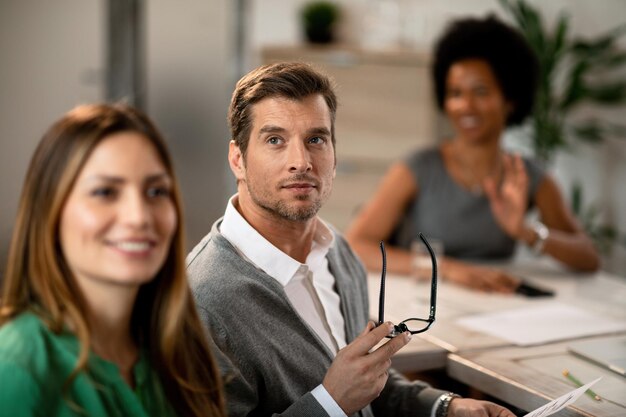 Mid adult businessman having a meeting with colleagues in board room