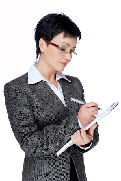 Free photo mid adult businesswoman in grey business suit writing