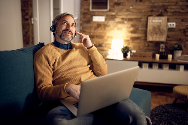 Mid adult entrepreneur talking during video call from home at night