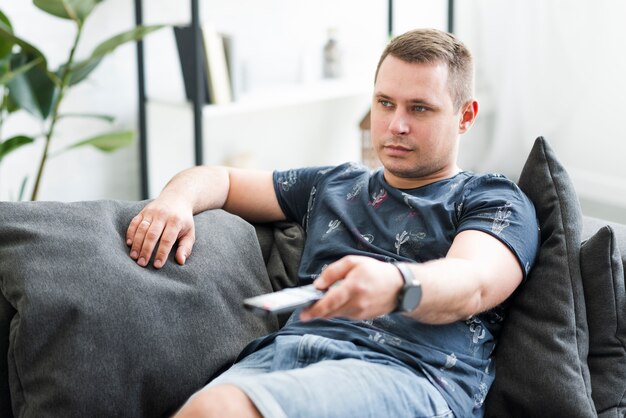 Mid adult man sitting on sofa watching tv