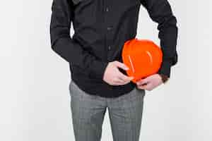 Free photo mid section of an architect holding orange clipboard over white backdrop