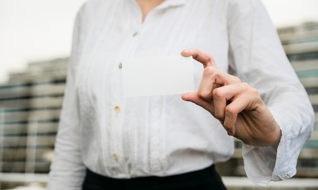 Mid section of a businesswoman showing blank visiting card