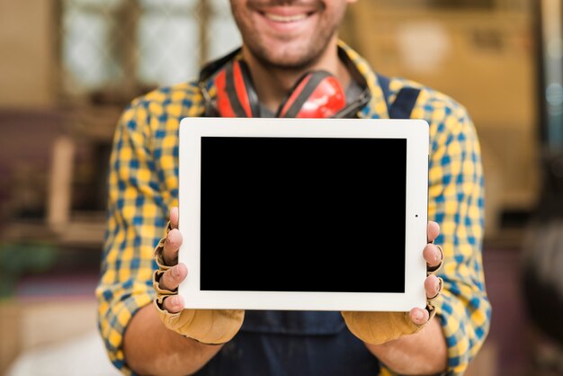 Mid section of a carpenter showing digital tablet with blank screen