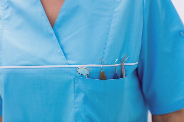 Foto gratuita metà di sezione del dentista che porta gli strumenti dentali in tasca