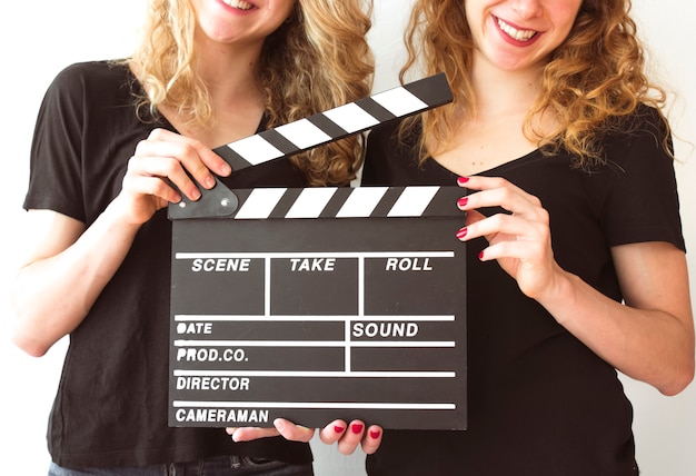 Mid section of female sister holding clapperboard