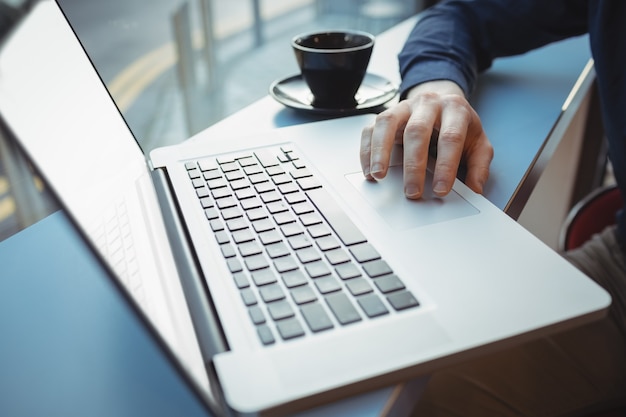 Mid-section of male executive using laptop