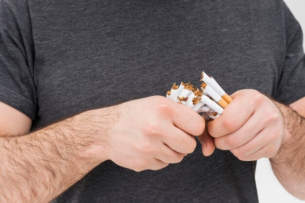 Mid section of a man breaking the cigarettes with hands
