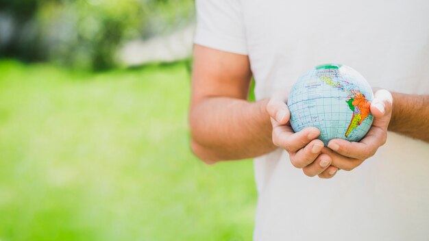 Mid section of man holding globe in hand
