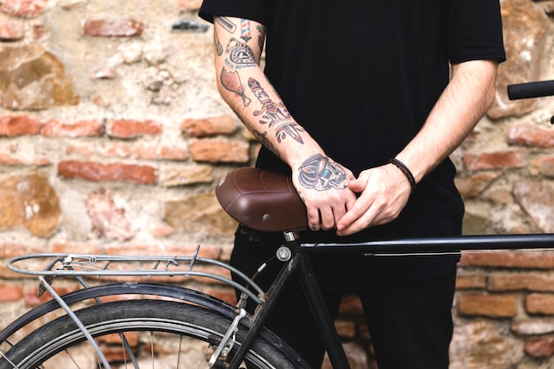 Mid section of a man standing near the bicycle