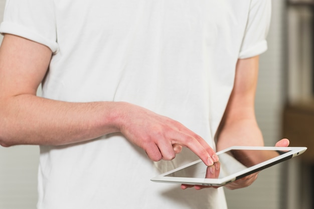 Mid section of a man touching the digital tablet screen with fingers